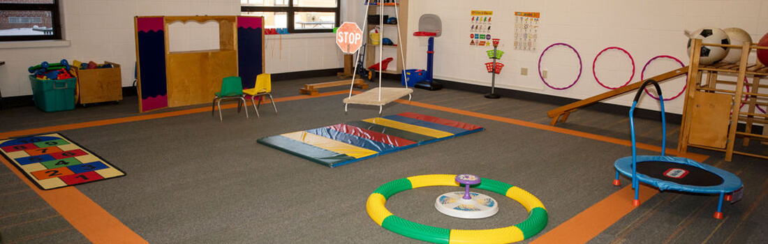 Large open classroom with games and trampoline